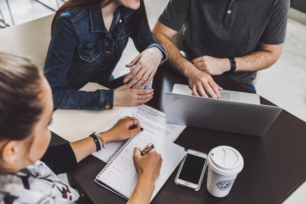 Group of three students collaborate together at the Faculty of Law cafe